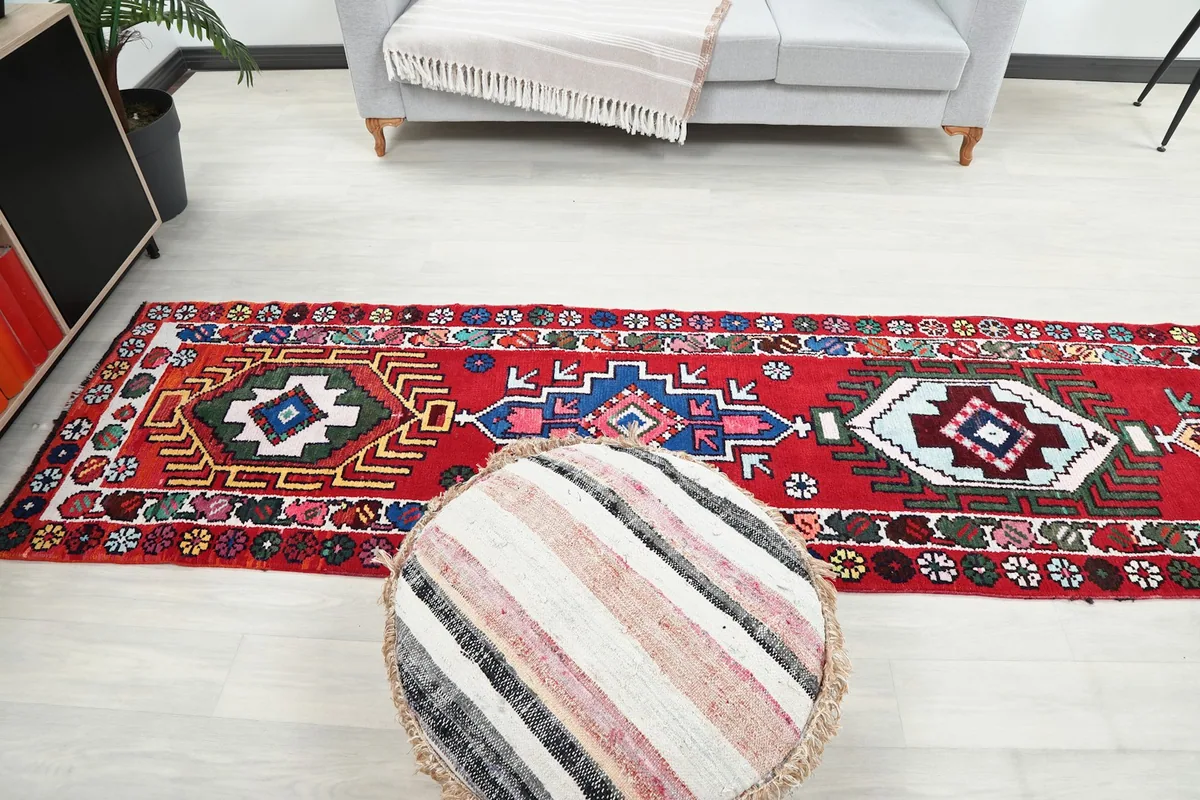 Top-down view of the runner rug in a room setting, next to a sofa and ottoman