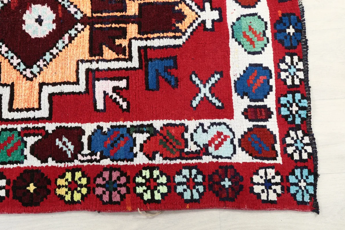 Detail of the colorful floral border and geometric patterns at the end of the runner rug