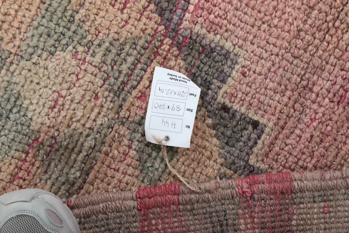 Close-up of the rug's pile and a tag with product information, showing the texture and colors.
