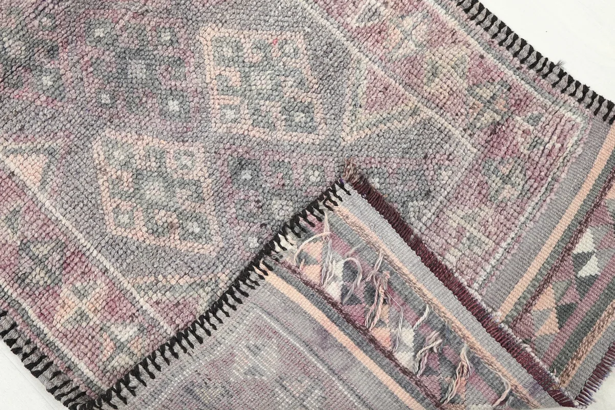 View of the back of the hand-knotted rug, revealing the foundation and knotting technique.