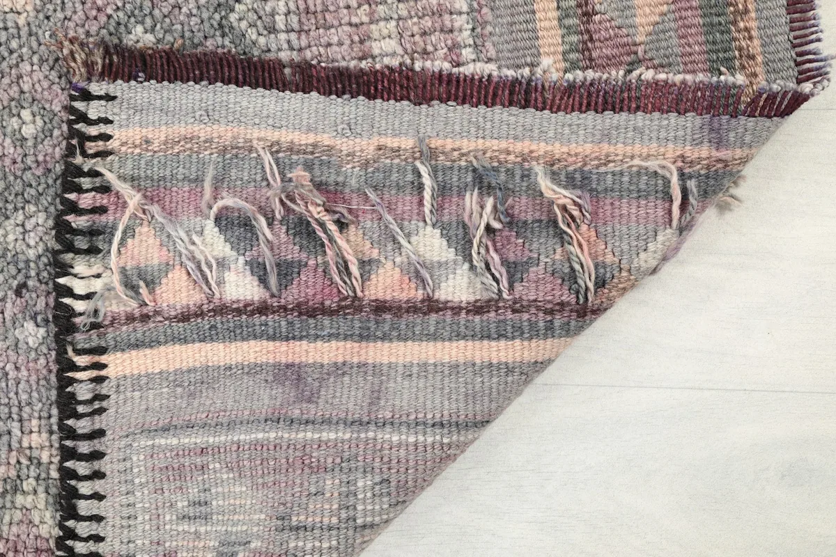 Close-up of the rug's fringe and the tightly woven end finish.