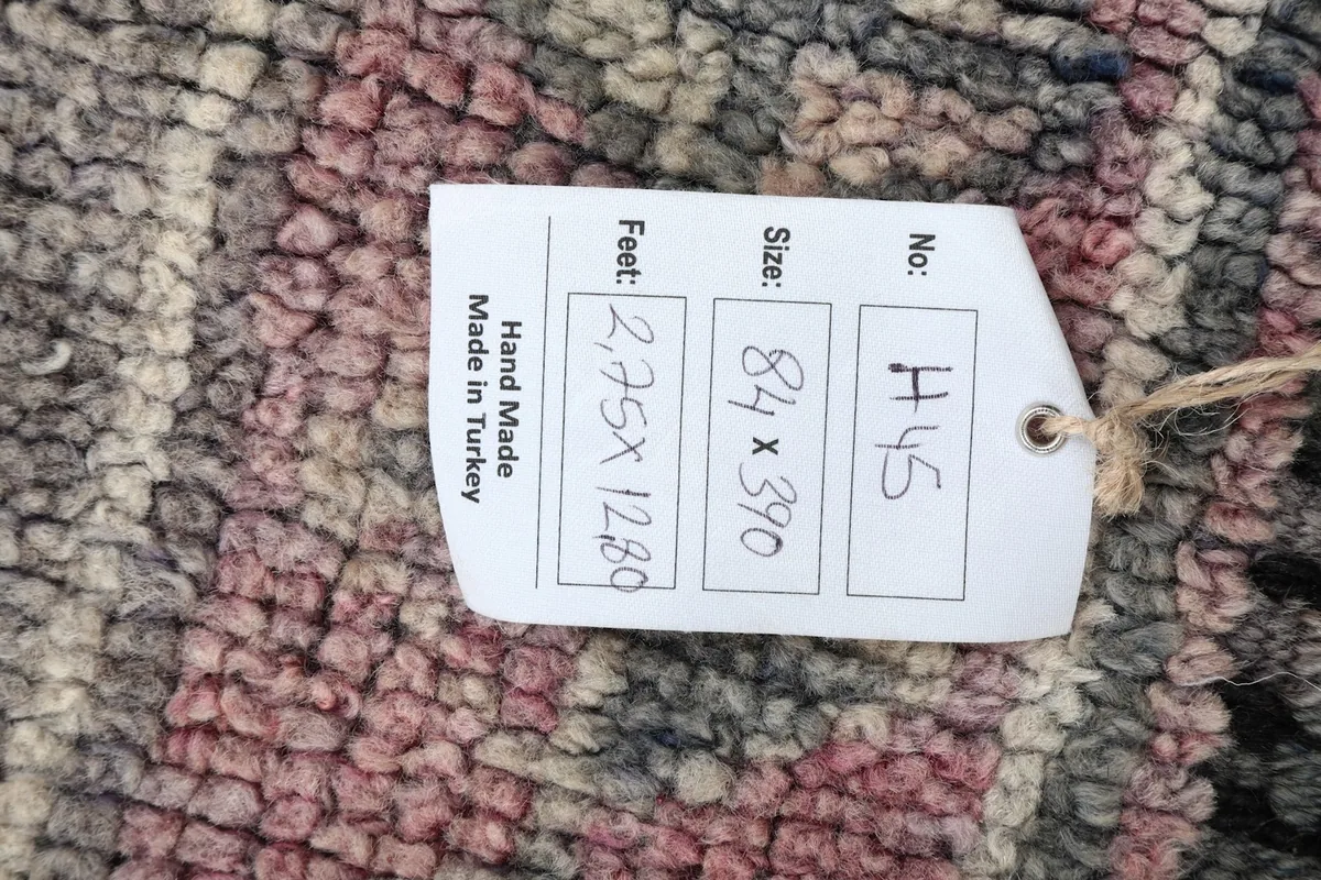 Product tag showing the rug's dimensions in feet and centimeters, and origin.
