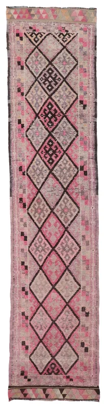 Full overhead view of the vintage pink and gray geometric Anatolian runner rug on a white background