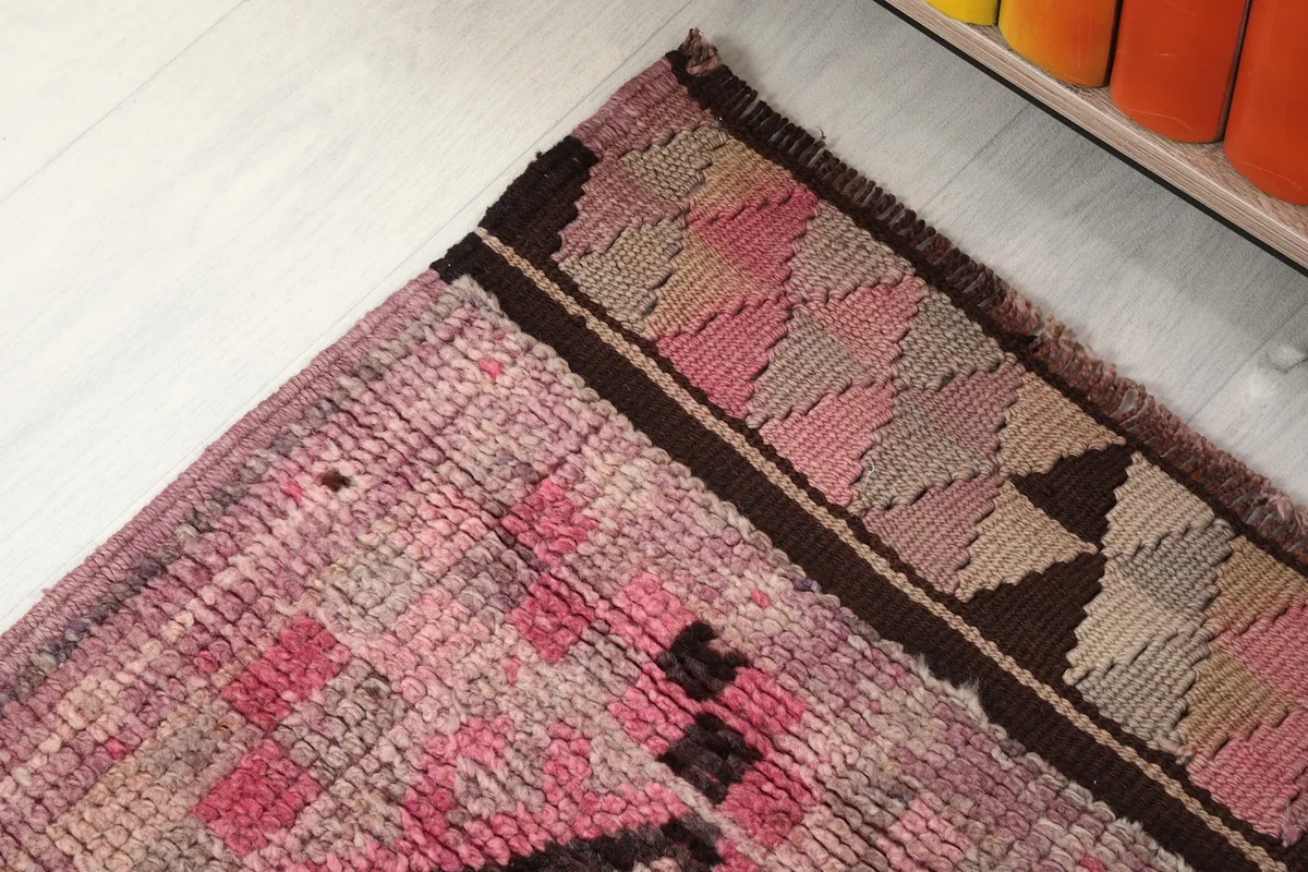Detail of the upper border and a portion of the main pink and gray geometric pattern