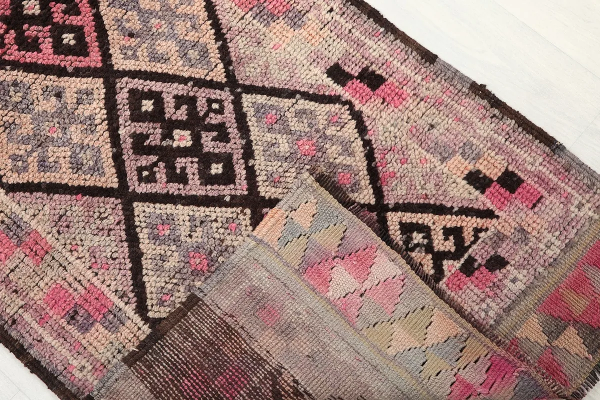 Folded corner of the runner rug showing the geometric pattern and the reverse side
