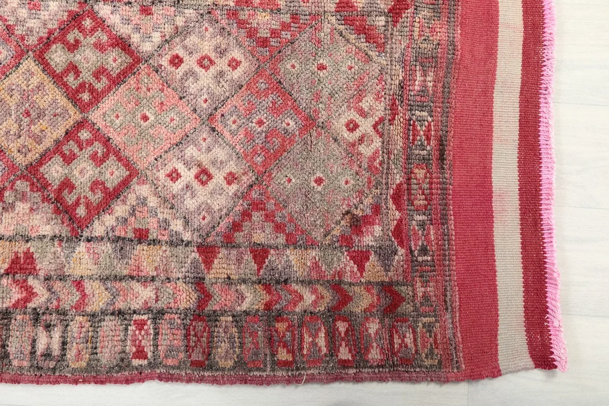 Detailed view of the intricate geometric motifs and border on the rug