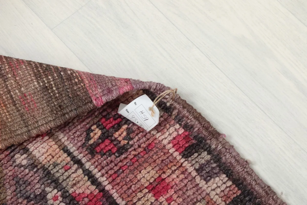 Corner of the rug with a tag, showing the reverse side's texture