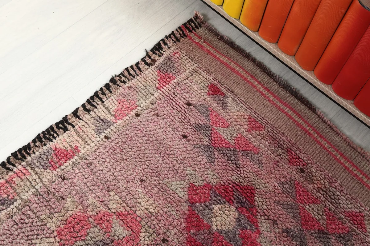Corner detail of the runner rug, highlighting the border design, fringe, and the hand-knotted structure.