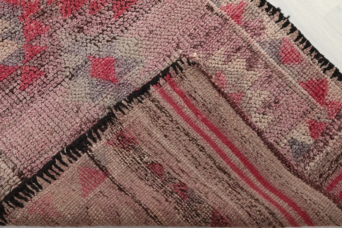 View of the back of the hand-knotted rug, revealing the cotton foundation and the reverse of the patterns.