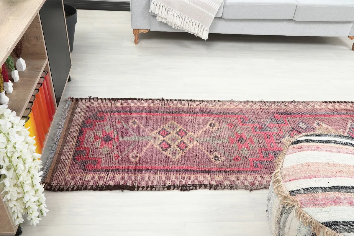 Long view of the rose runner rug extending through a room, showcasing its length and design.