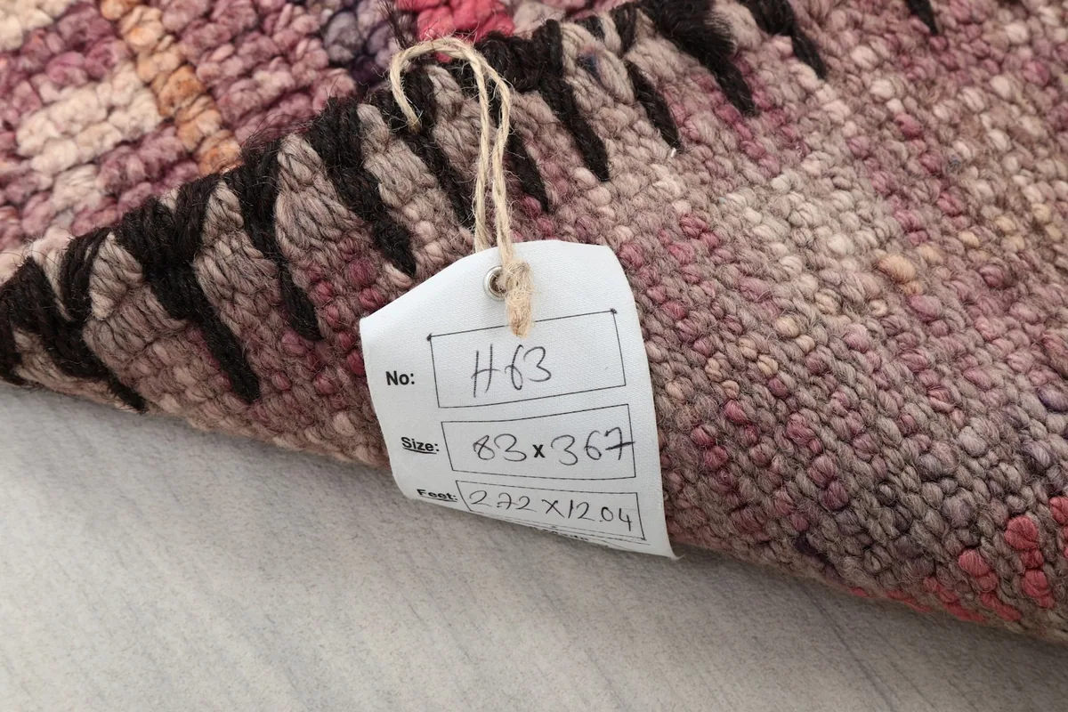 Tag attached to the rug's back, displaying its unique identifier and dimensions in centimeters and inches.