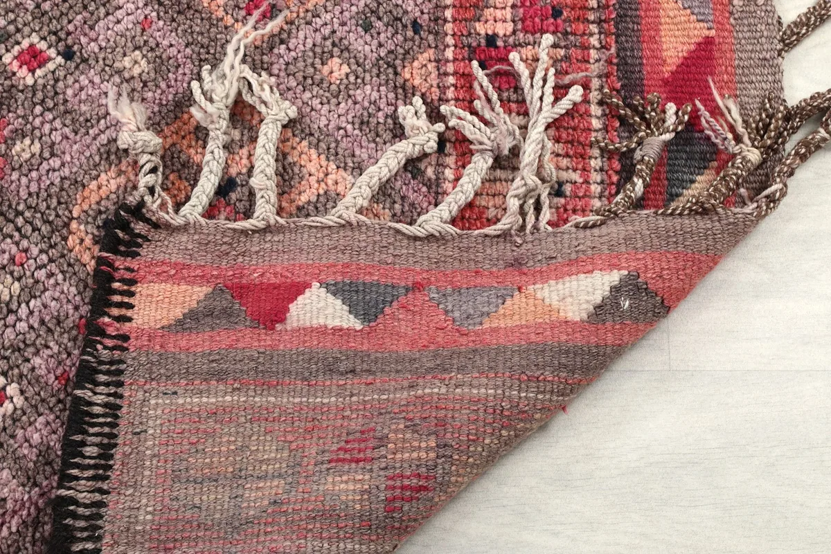 Close-up of the rug's fringe and the tightly woven edge, displaying craftsmanship