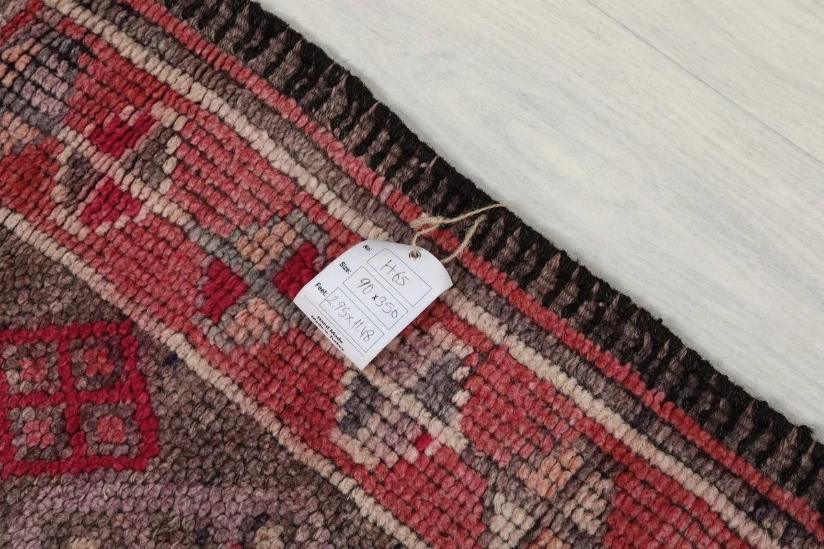 Corner of the rug with a tag, showing the wool pile and cotton foundation detail