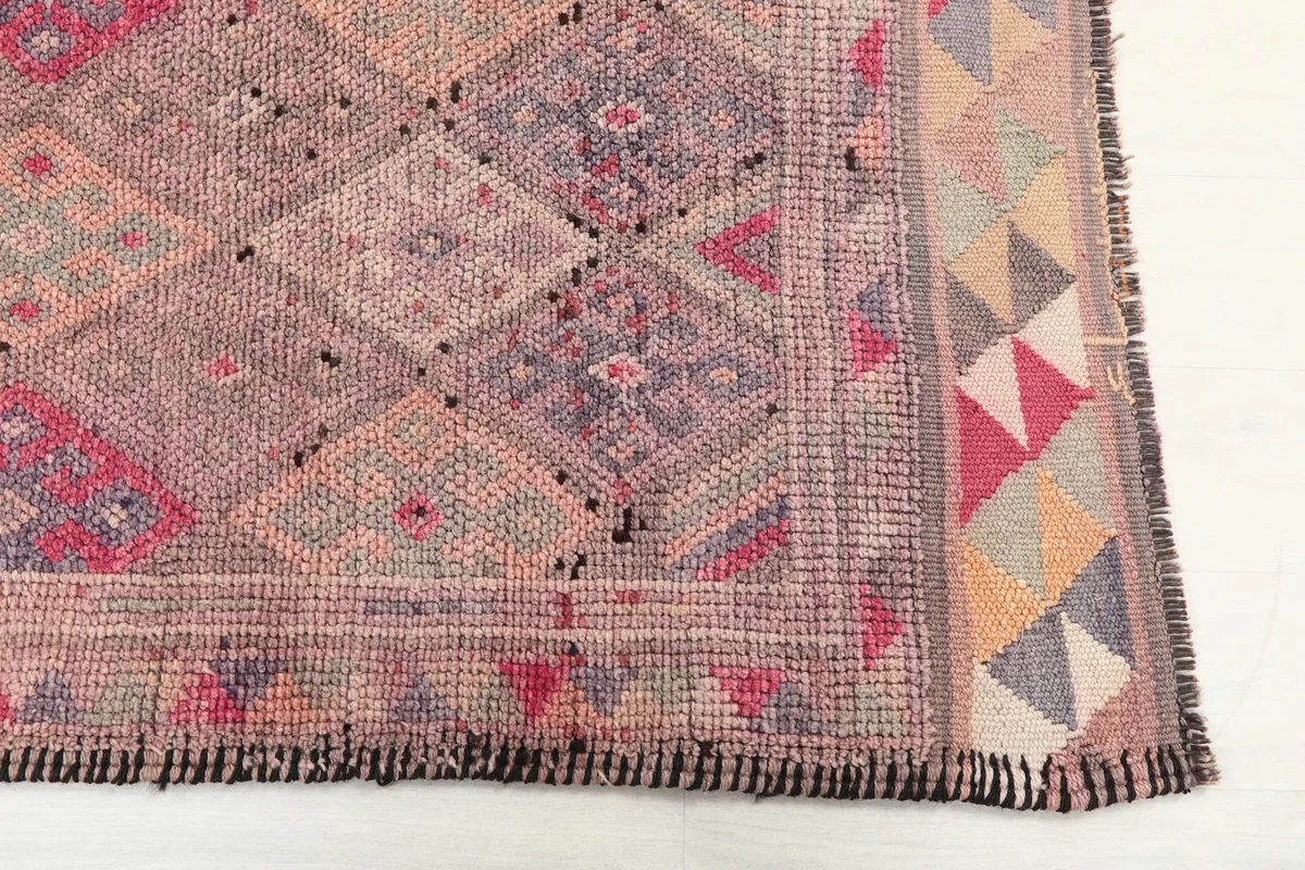 Detail view of the intricate geometric motifs and border design of the rug
