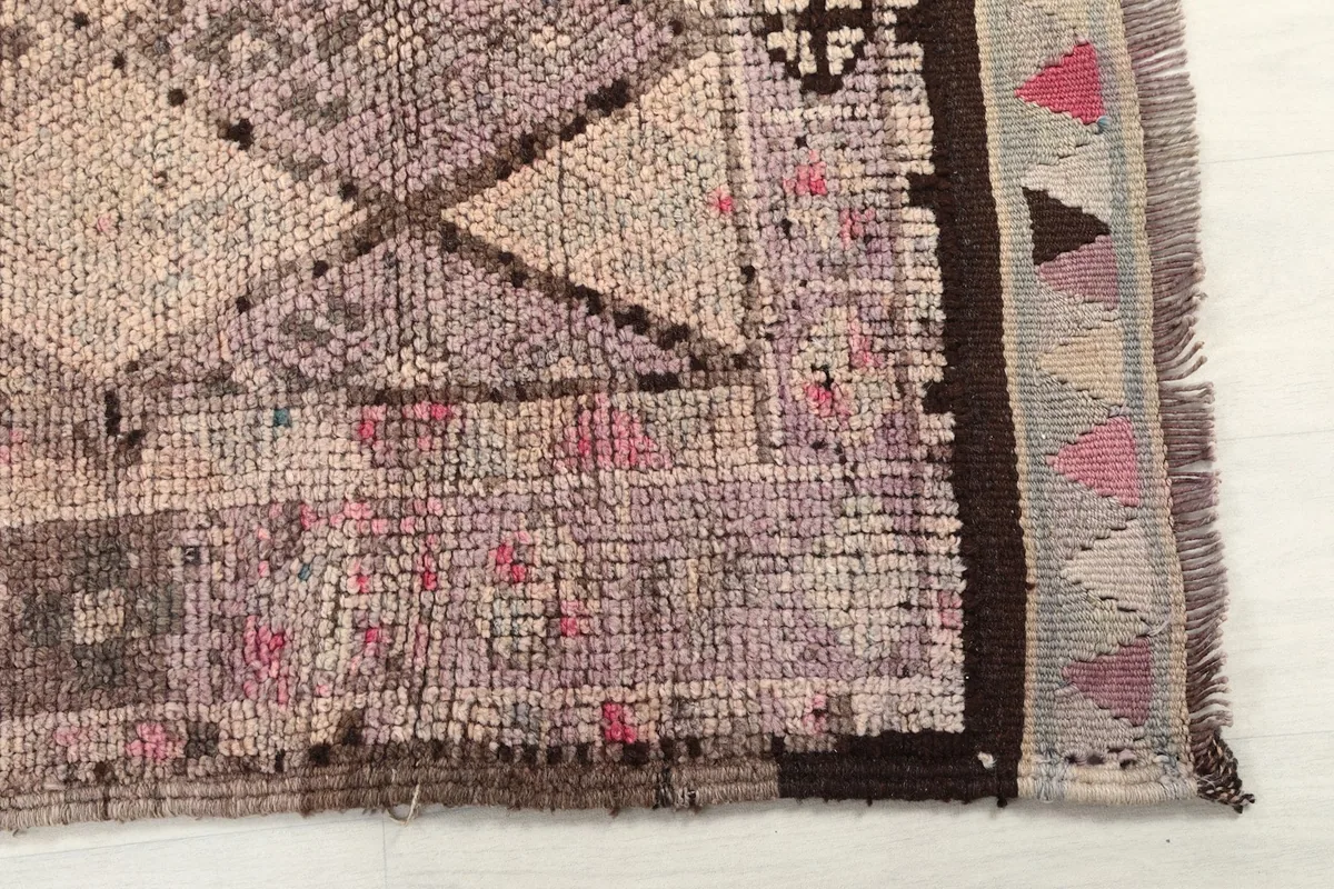 Detailed view of the rug's border and fringe, showcasing the hand-knotted texture and color variations.