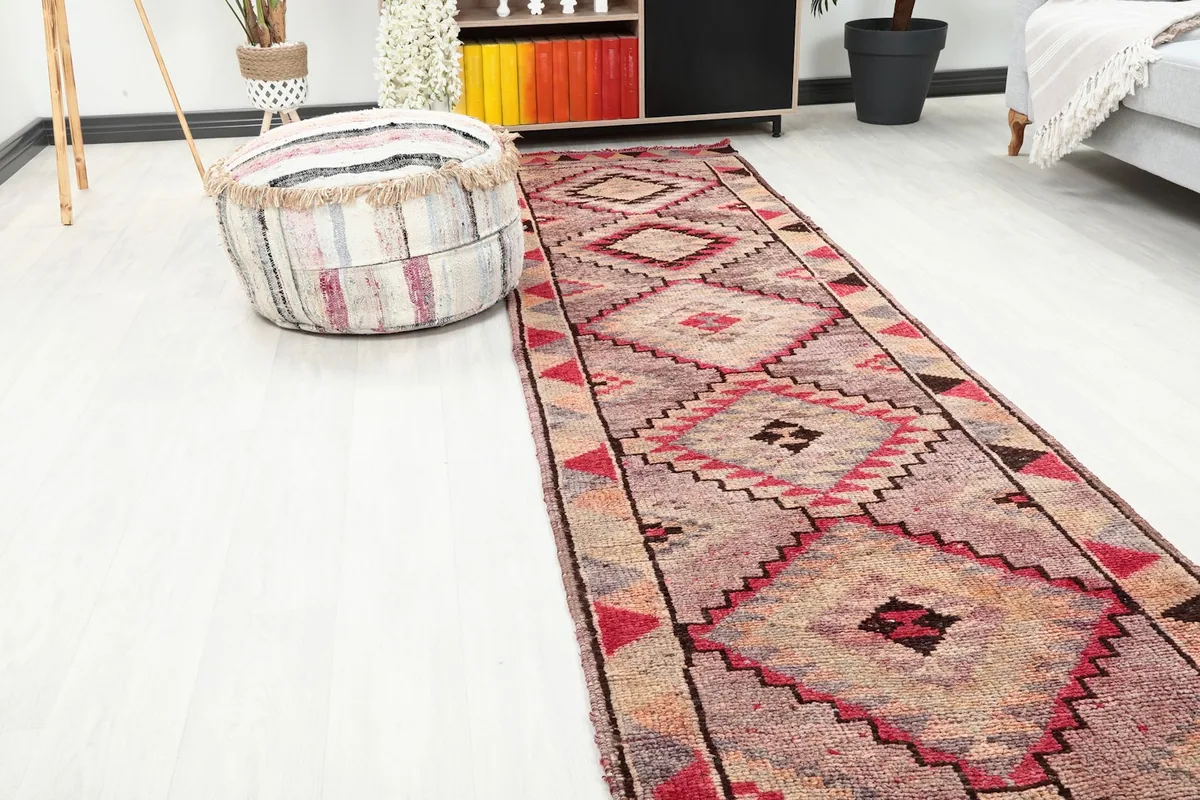 Close-up view of the rose and gray geometric runner rug extending through a room