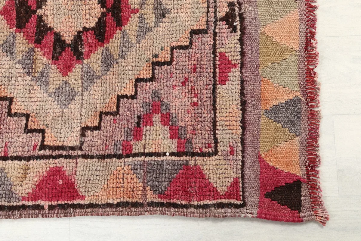 Detailed view of the end border and fringe of the rose and gray Anatolian runner rug