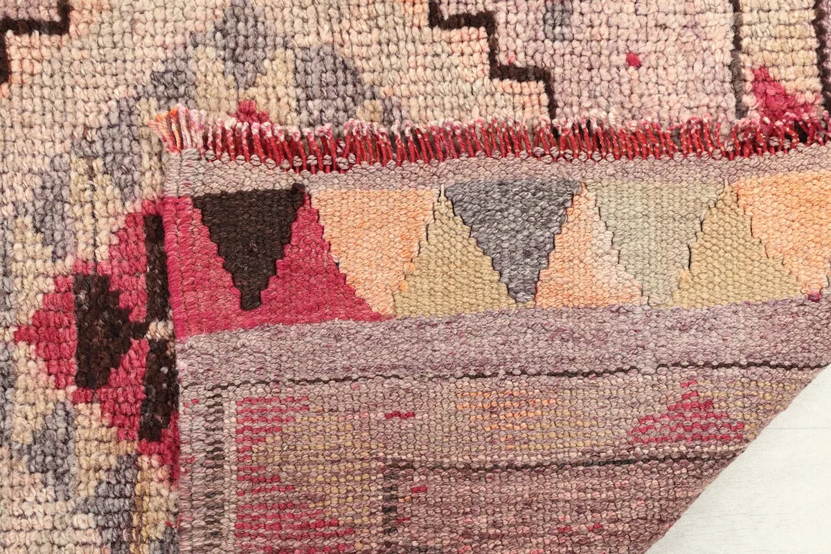 Detail of the rug's fringe and a folded edge, revealing the construction and colors