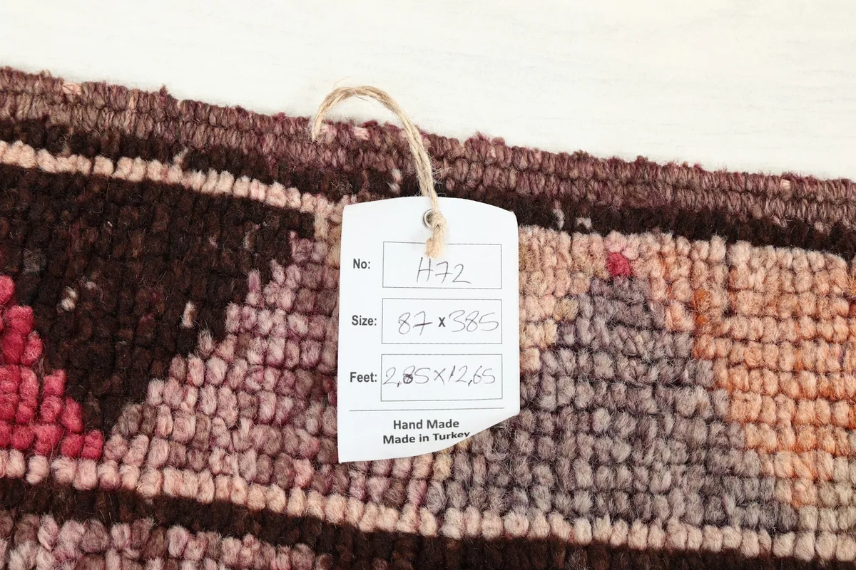 Product tag displaying the rug's dimensions and origin, resting on the rug's pile