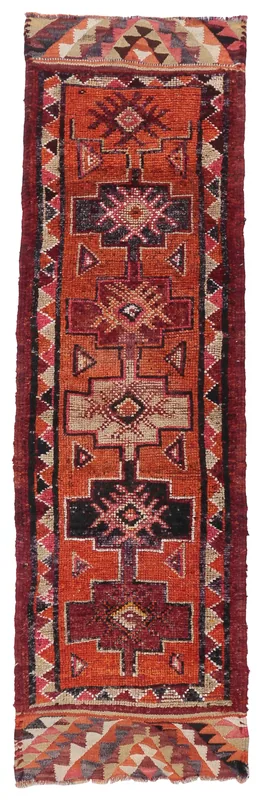 Full overhead view of the rust and black geometric Anatolian runner rug on a white background