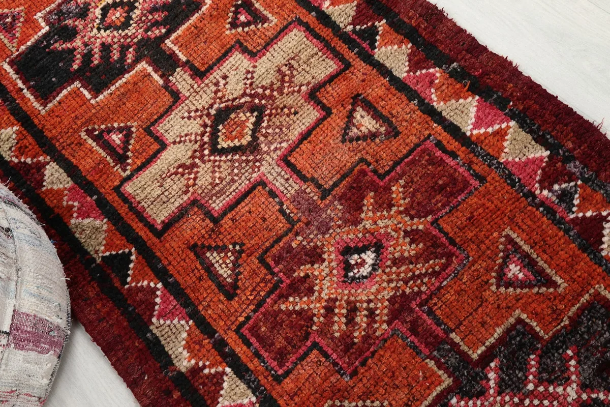 Close-up of the central geometric motifs in rust, black, and beige tones