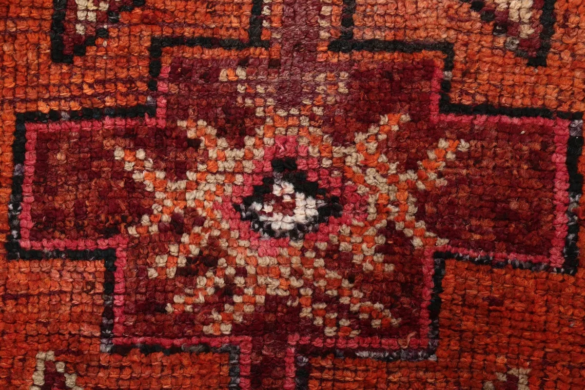 Extreme close-up showing the hand-knotted wool pile and texture of the rug
