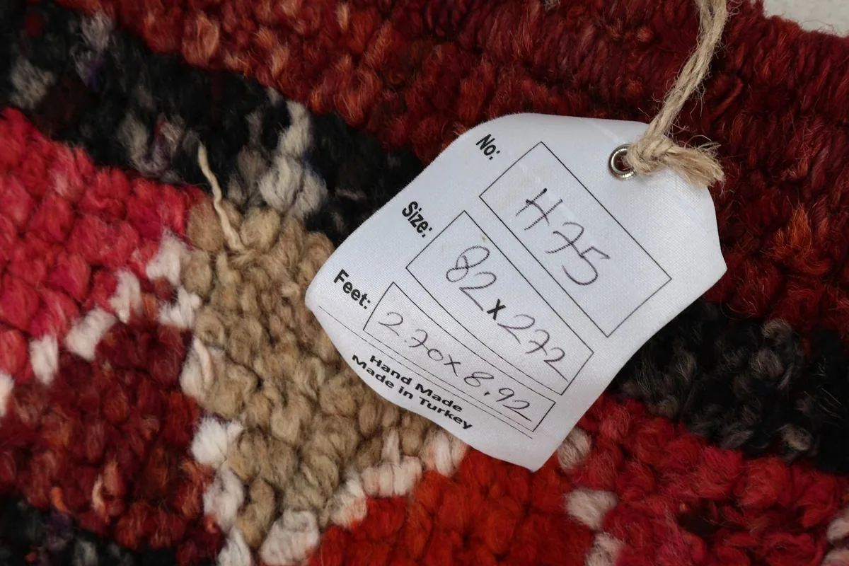 Close-up of the rug's texture with a product tag showing size and origin details