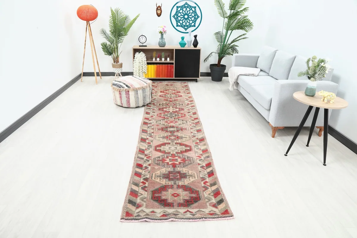Rose geometric runner rug displayed in a modern living room setting along a white wall