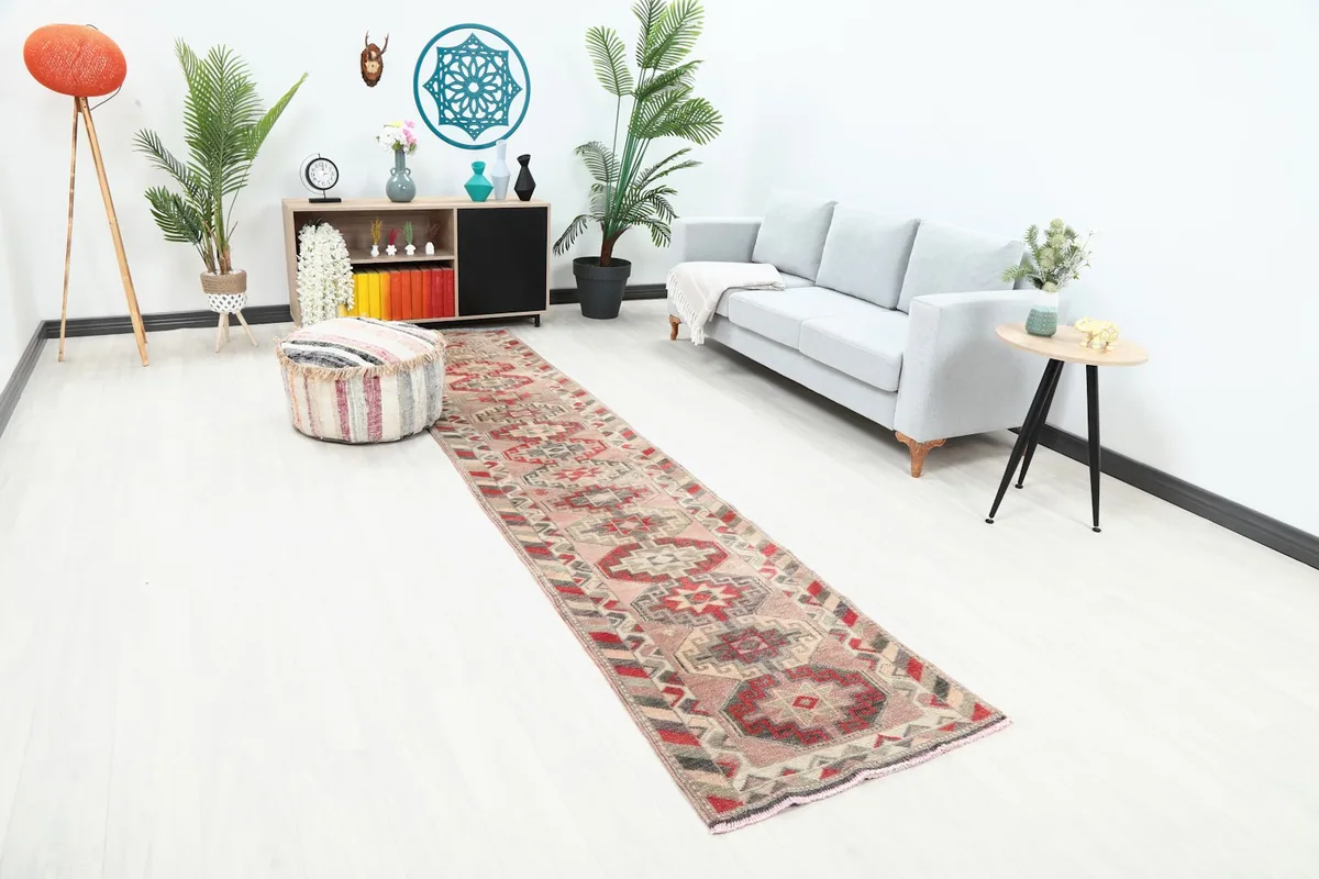 Angle view of the rose runner rug in a room with a light gray sofa and wooden furniture