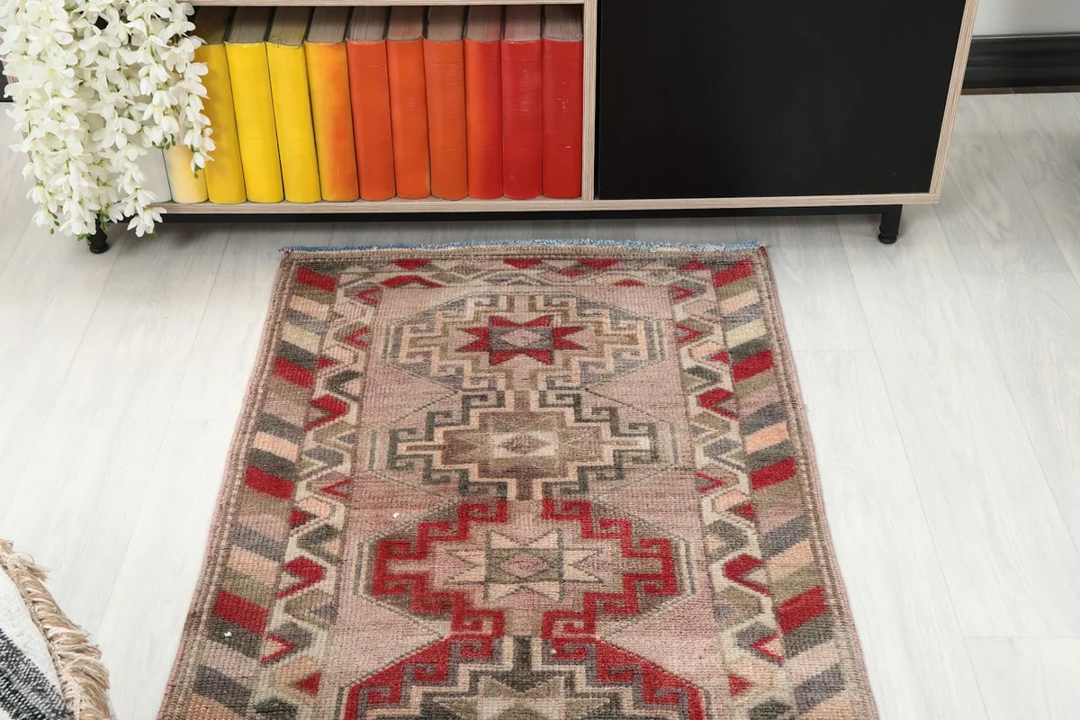 Overhead view of one end of the rose geometric runner rug in a room setting
