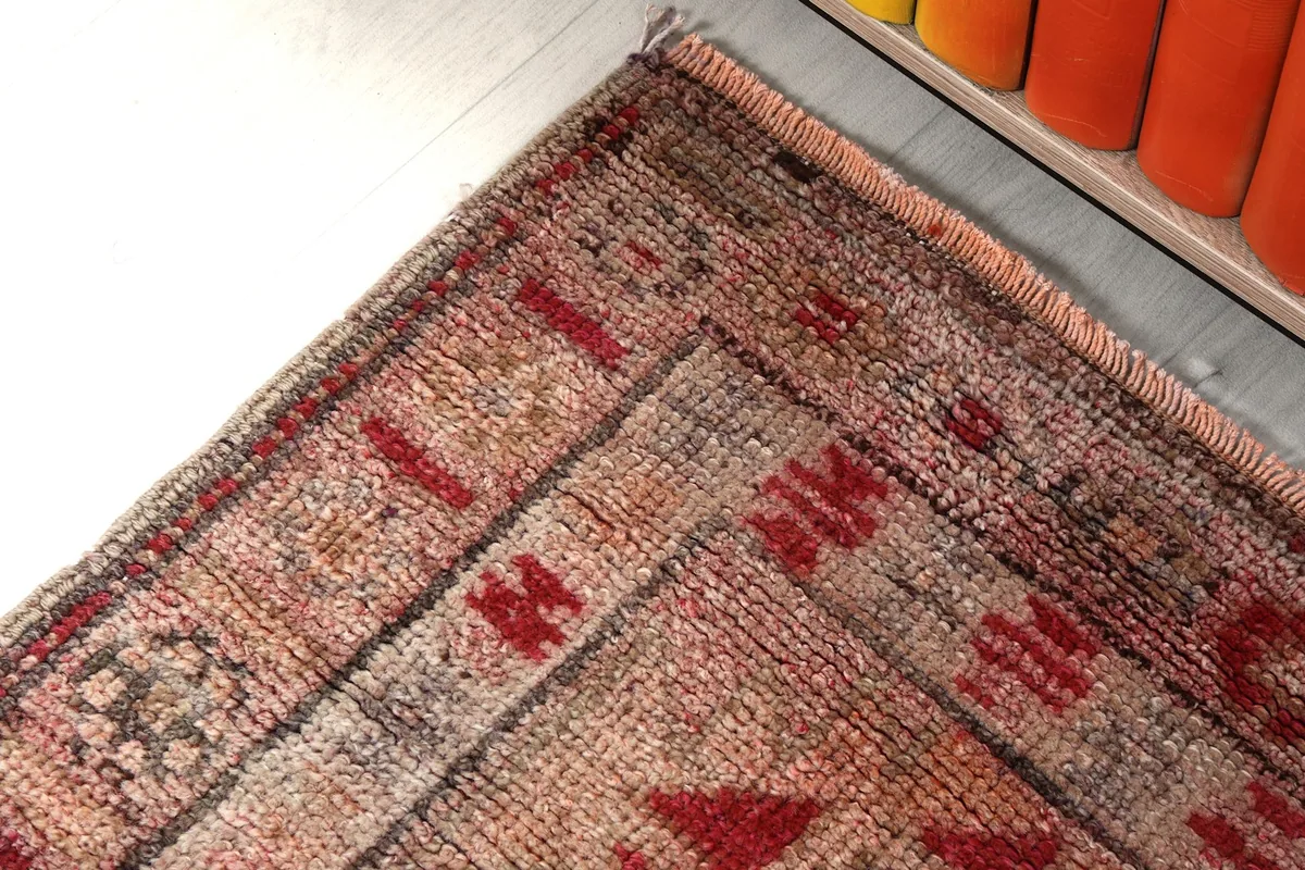 Corner detail of the runner rug, showing the intricate border design and the soft fringe.