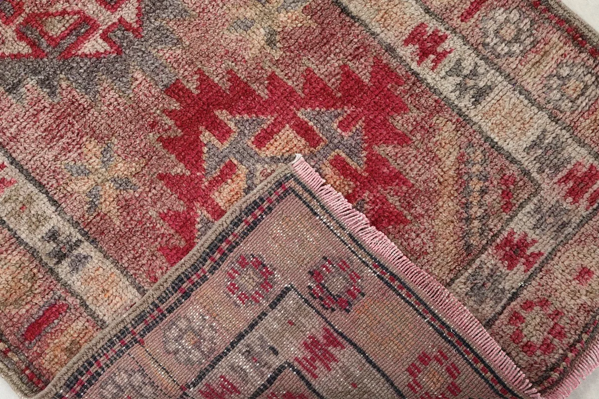 Folded corner of the rug revealing the hand-knotted construction on the reverse side.