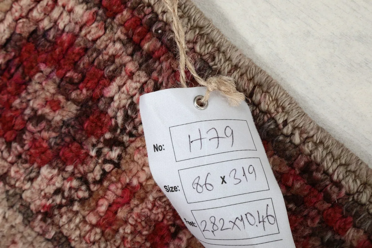 Tag attached to the rug displaying its unique item number and dimensions.