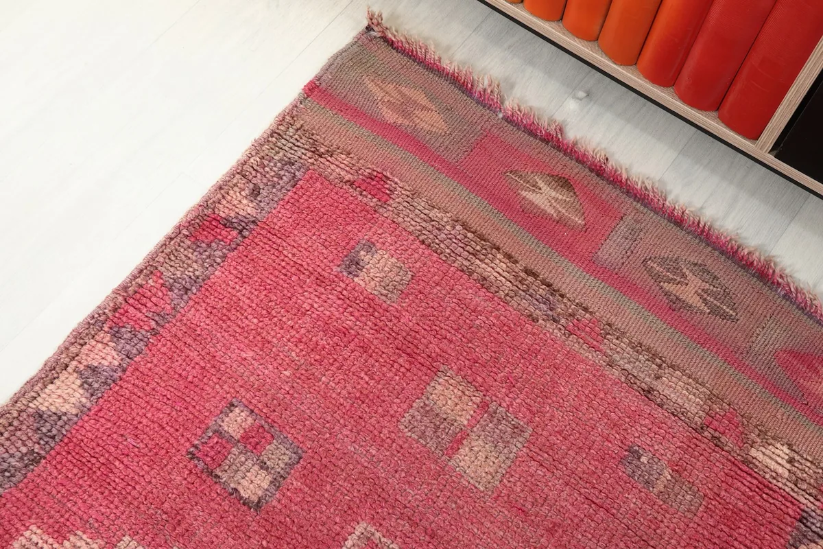 Detailed view of the rug's border and corner, highlighting the distinct colors and patterns.