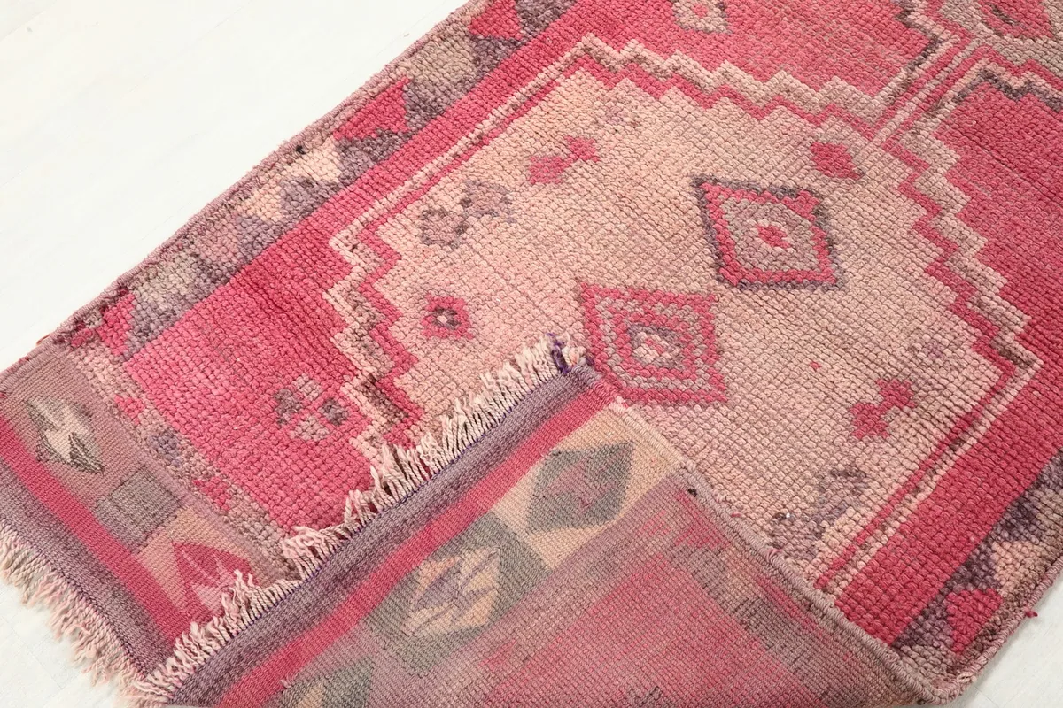 Close-up showing the low wool pile and the hand-knotted texture of the vintage rug.