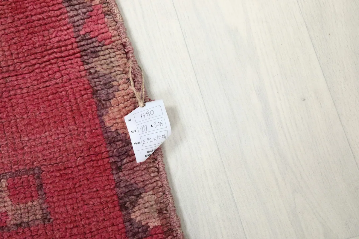 Corner of the rug with a size tag, showing the wool pile and fringe details.