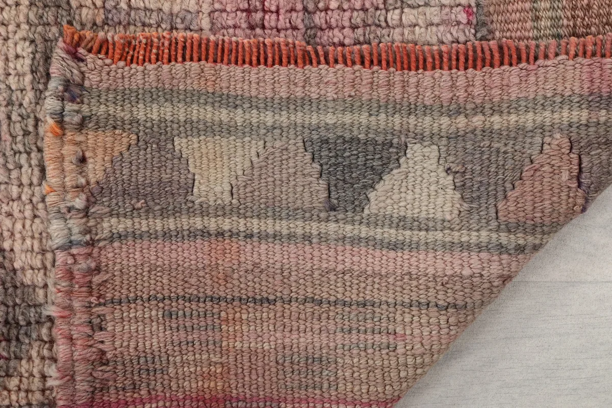 Detailed view of the rug's edge, showcasing the finished border and small fringe