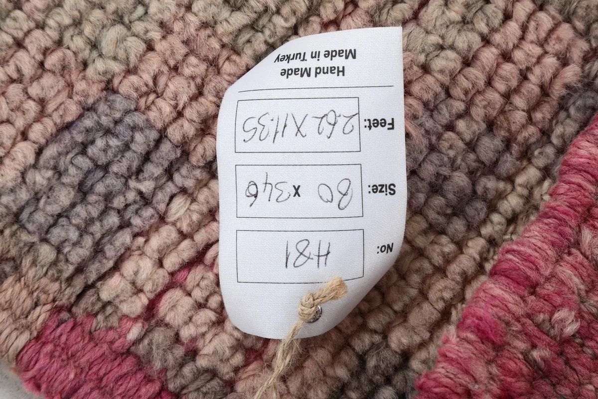 Product tag displaying the rug's dimensions in feet and centimeters, confirming its origin
