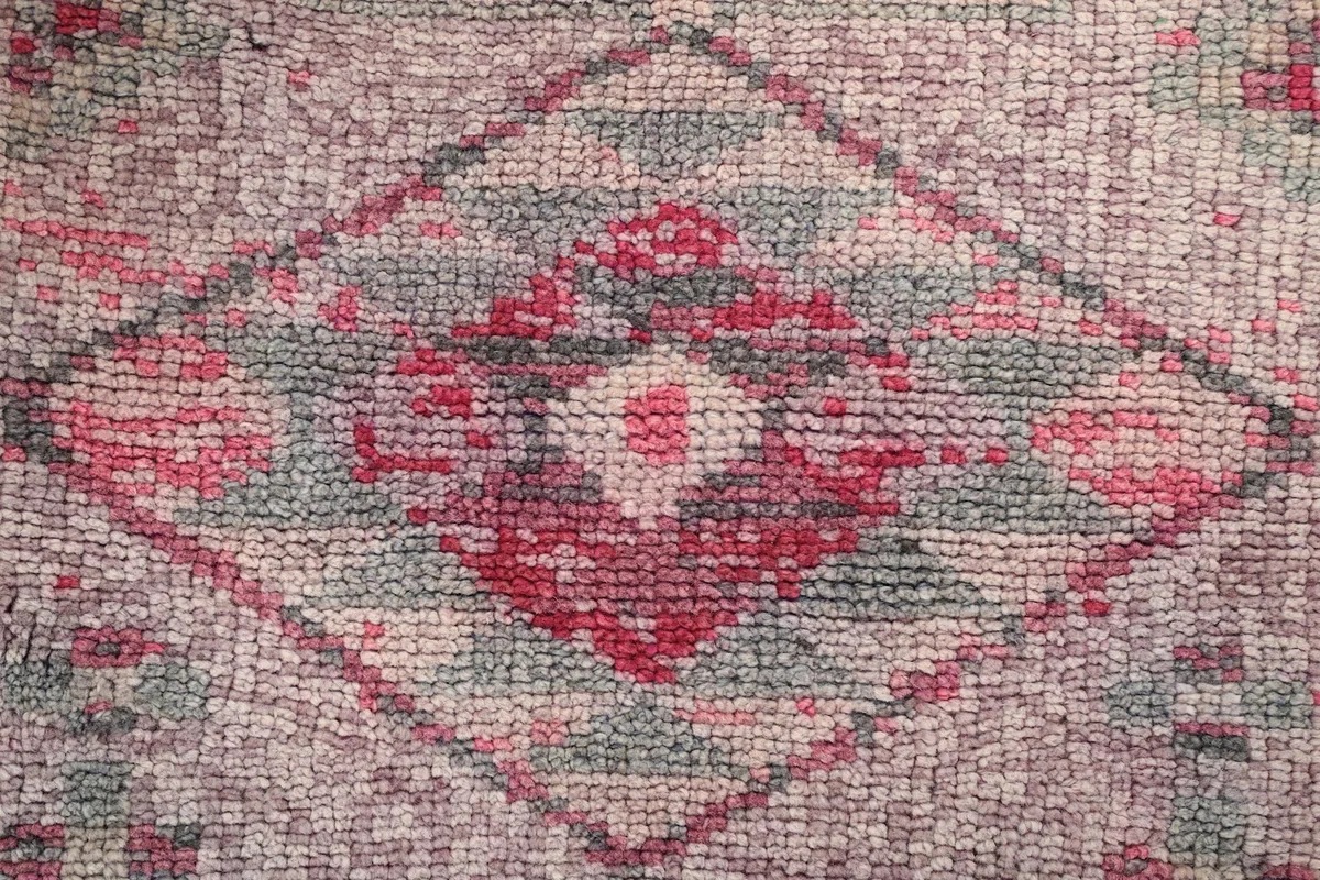 Macro detail of the hand-knotted wool pile and faded colors
