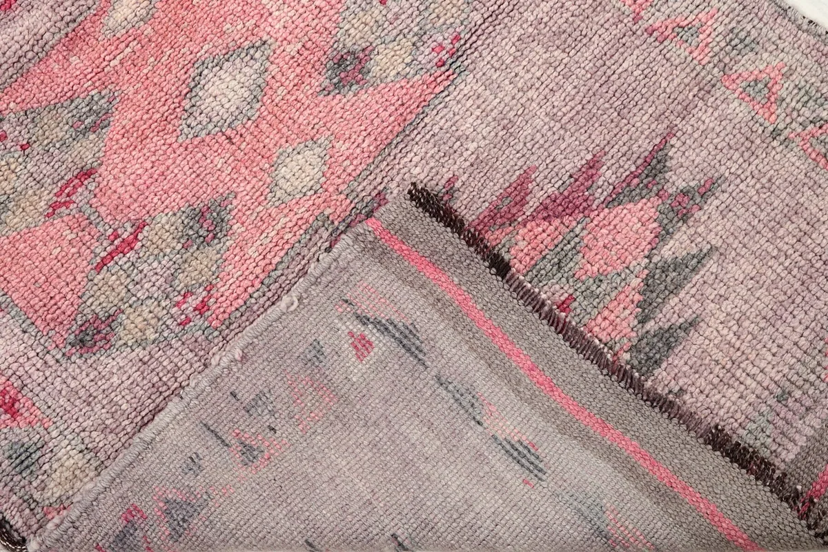 View of the rug's back, showing the cotton foundation and hand-knotting