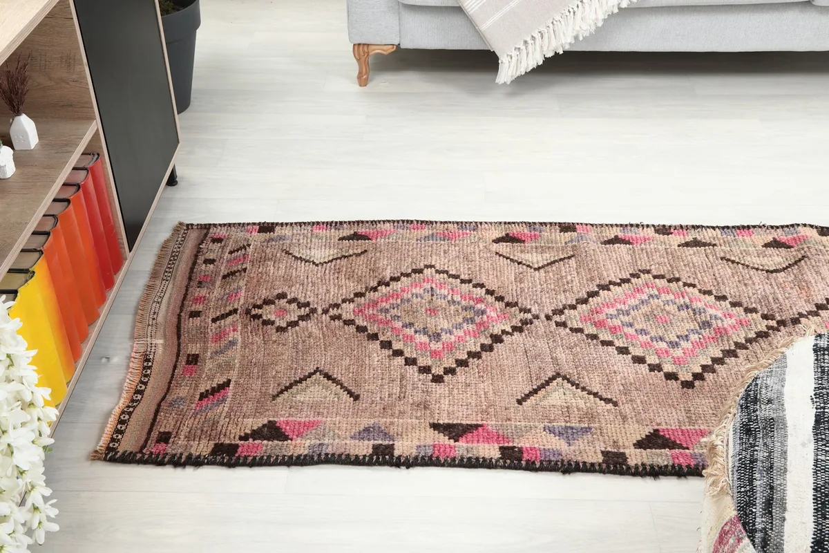 Runner rug laid out in a room, showing its full length from a lower angle