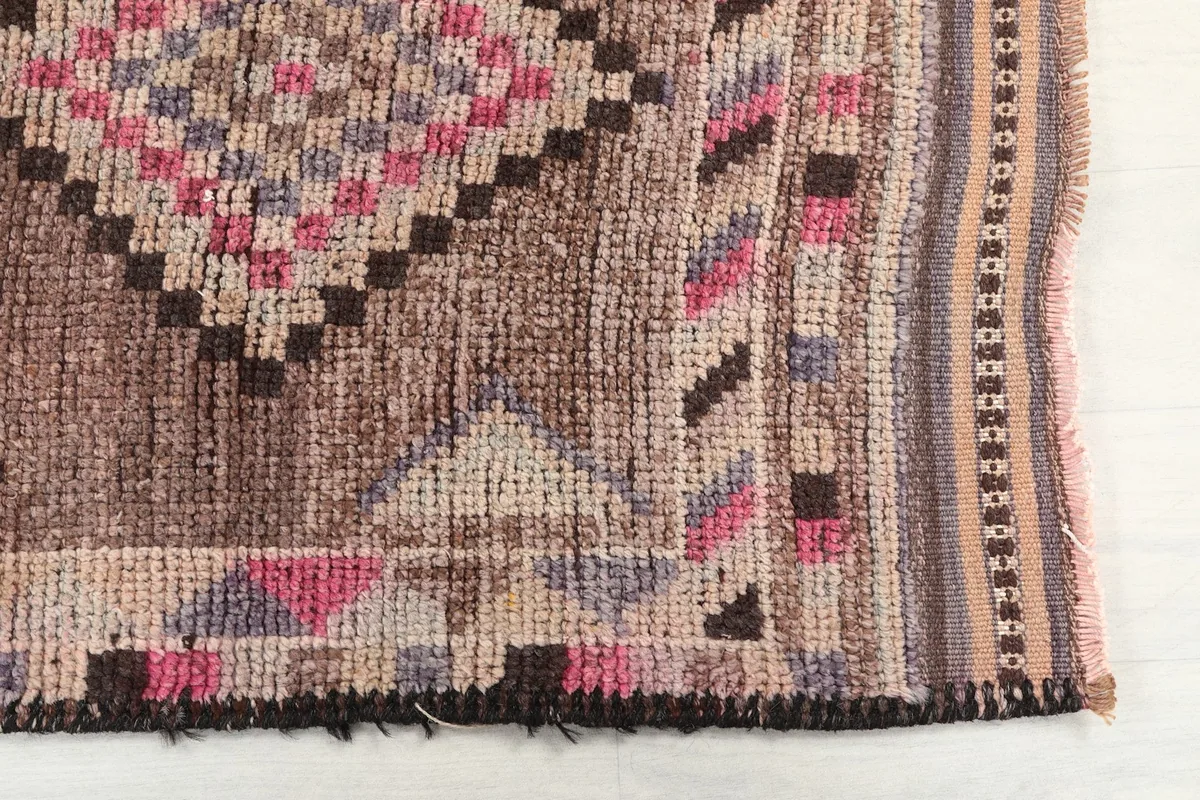 Detailed view of the rug's edge, showing the geometric border and colors