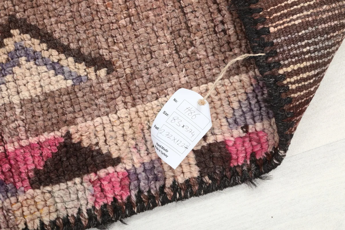 Corner of the runner rug with a product tag attached, showing texture and weave
