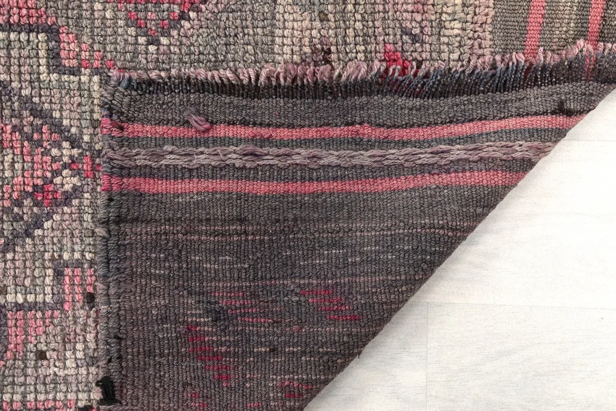 Close-up of the rug's reverse side, revealing the hand-knotted cotton foundation and wool pile
