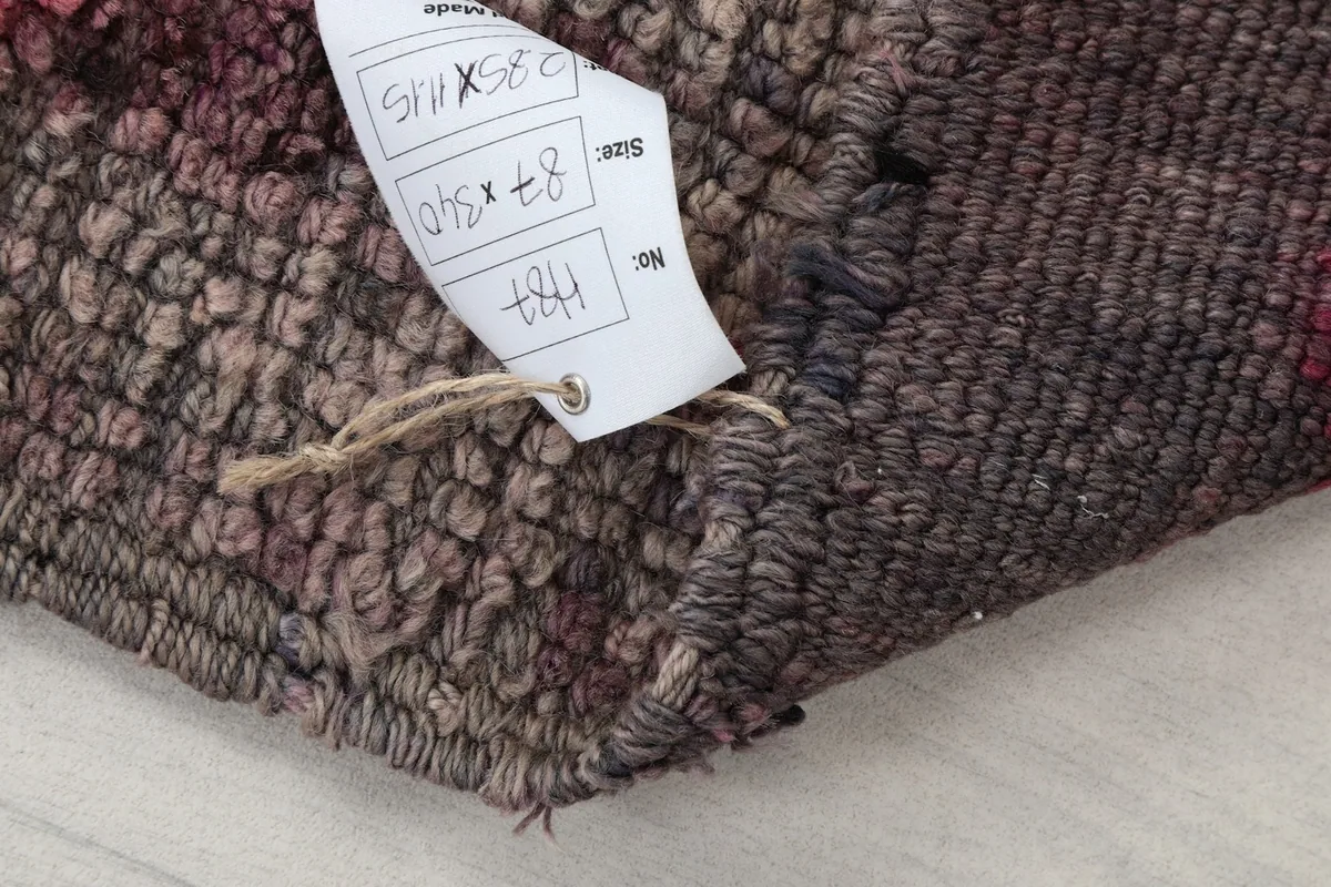 Detail of the rug with a size tag showing dimensions 2'10" x 11'2" (87 x 340 cm)