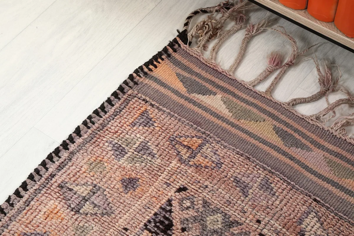 Close-up of the runner's edge, highlighting the woven border design and the short, natural fringes.