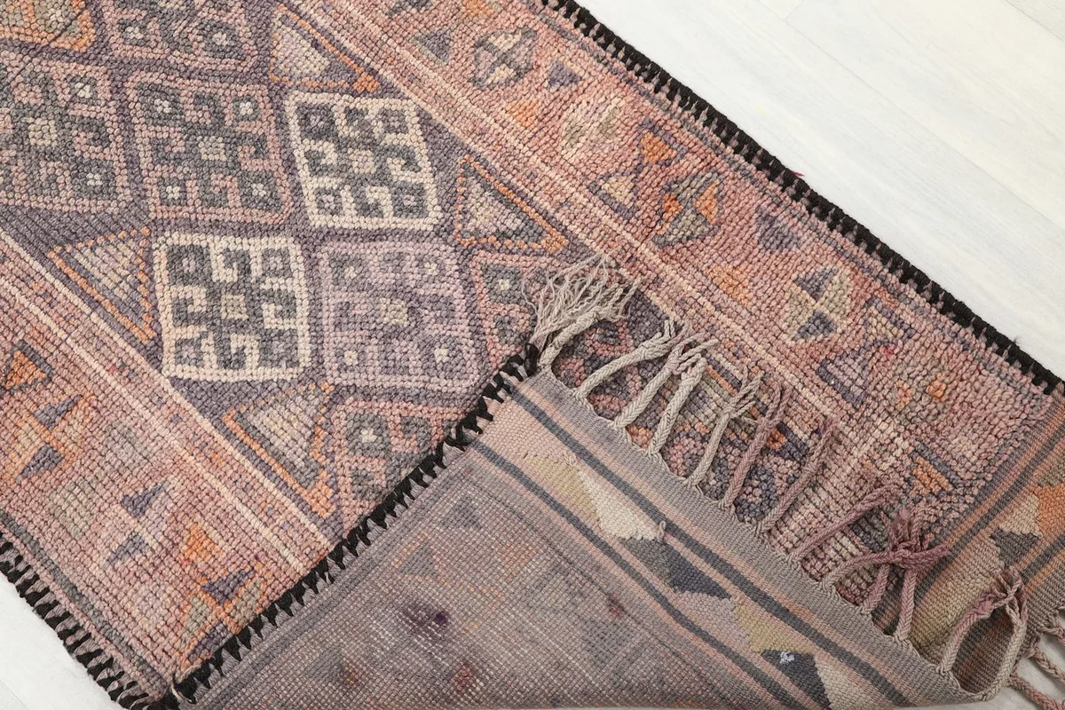 View of the runner's underside and corner, showing the tightly woven cotton foundation and the pile from the reverse side.
