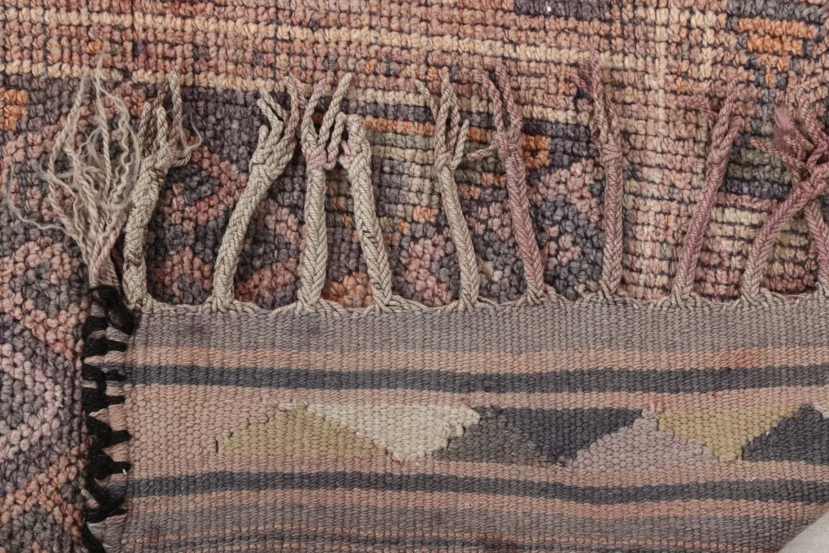 Close-up of the runner's hand-tied fringes and the flat-woven end border with geometric details.