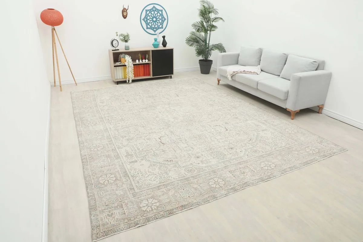 Large beige and gray Persian rug complementing a modern living room setting with a light sofa.