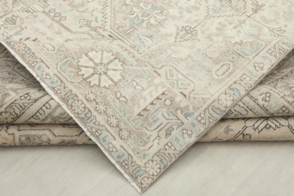 View of a folded corner of the rug, displaying the thickness and texture of the wool pile.